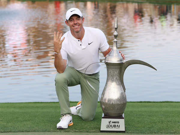 Rory McIlroy berpose dengan trofi Dubai Desert Classic 2024 sambil mengacungkan empat jari. (Foto: Golf Digest)