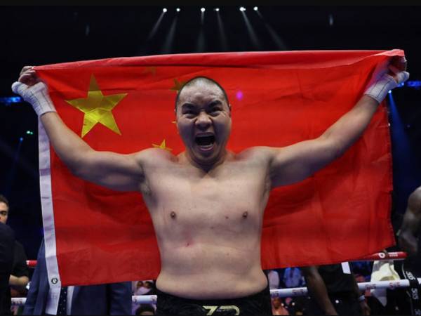 Zhilei Zhang merayakan kemenangannya atas Deontay Wilder sambil mengibarkan bendera negaranya. (Foto: Matchroom Boxing)