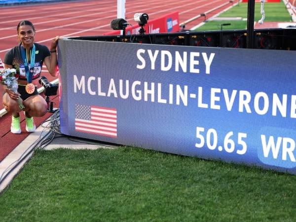 Sydney McLaughlin-Levrone berpose dengan papan pencatat waktu setelah memecahkan rekor dunia lari gawang 400 meter putri. (Foto: AP)