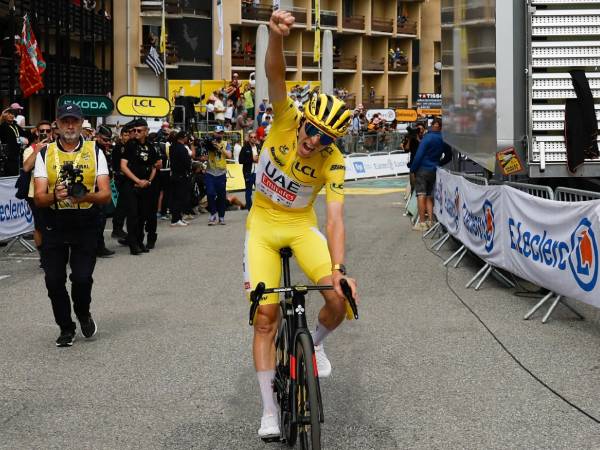 Tadej Pogacar melakukan selebrasi setelah memenag etape 14 Tour de France pada Sabtu (13/7). (Foto: AFP)