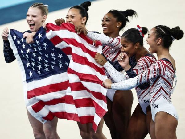 Simone Biles (tengah) dan keempat rekannya merayakan sukses menggondol emas senam beregu putri di Olimpiade Paris. (Foto: AP)