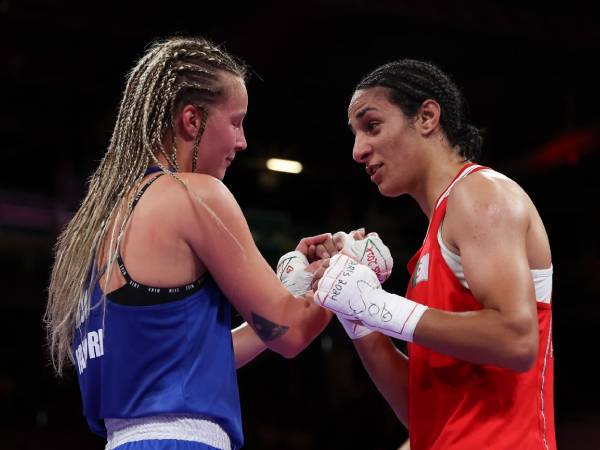 Imane Khelif (kanan) menjabat tangan Anna Luca Hamori setelah pertarungan mereka di babak perempat final kelas 66kg putri di di Olimpiade Paris pada Sabtu (3/8). (Foto: AFP)