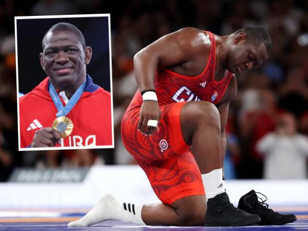 Mijain Lopez melepaskan sepatunya di atas matras setelah memenangi medali emas di kelas Greek-Roman 130 kg putra pada Selasa (6/8). (Foto: AP)