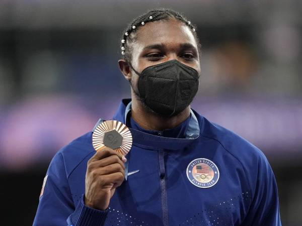 Noah Lyles kembali ke lintasan pada Jumat (9/8) malam dengan mengenakan masker pelindung saat menerima medali perunggu. (Foto: AP)