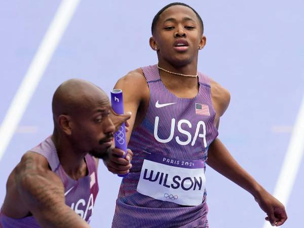 Quincy Wilson menyerahkan baton kepada pelari kedua AS Vernon Norwood dalam babak kualifikasi lari estafet 4x400 meter putra di Olimpiade Paris pada Jumat (9/8). (Foto: AP)