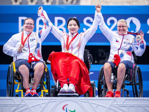 Chen Minyi (tengah) merayakan suksesnya di atas podium setelah memenangi panahan W1 perorangan putri di Paralimpiade Paris. (Foto: AP)