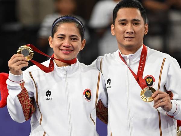 Hikmat Ramdani (kanan) dan Leani Ratri Oktila berpose dengan medali emas Paralimpiade pertama untuk kontingen Indonesia. (Foto: NPC Indonesia)