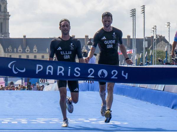 Luke Pollard (kanan) dan Dave Ellis bereaksi setelah mencapai garis finis triathlon Paralimpiade Paris. (Foto: AP)