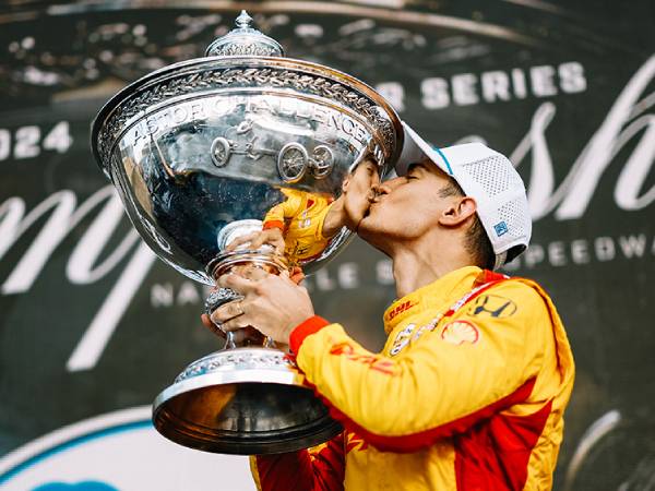 Alex Palou melakukan selebrasi dengan trofinya setelah memenangi IndyCar tahun ini. (Foto: AP)