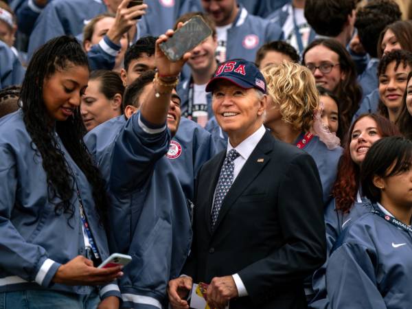 Presiden AS Joe Biden (bertopi biru) berdiri di tengah para atlet Amerika di South Lawn Gedung Putih. (Foto: AP)