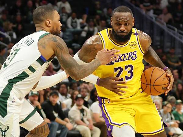 LeBron James (kanan) mencetak 11 poin saat Los Angeles Lakers menang 107-102 atas Milwaukee Bucks pada Kamis (10/10). (Foto: AP)