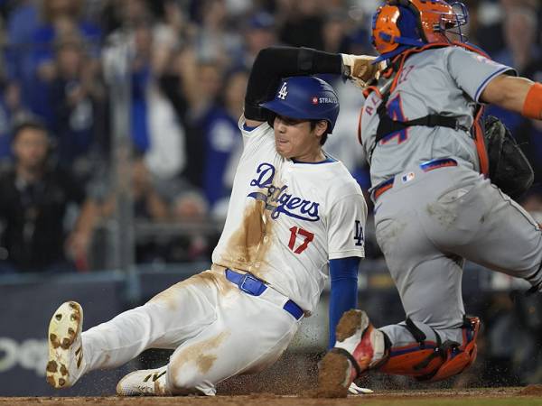 Bintang Los Angeles Dodgers Shohei Ohtani (kiri) mencetak poin versus Mets di Game 1 NLCS pada Minggu (13/10). (Foto: AP)