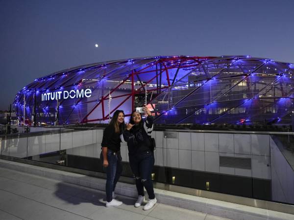 Beberapa penggemar Clippers berpose dengan latar belakang Intuit Dome. (Foto: AP)