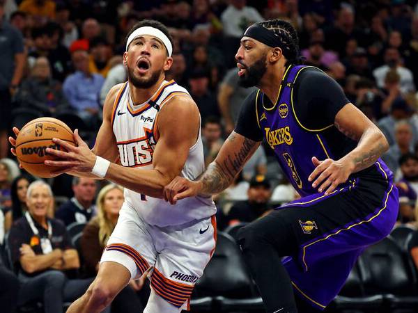 Devin Booker (kiri) mencetak 33 poin saat tuan rumah Phoenix Suns meraih kemenangan 109-105 atas Los Angeles Lakers pada Senin (28/10) malam. (Foto: AP)