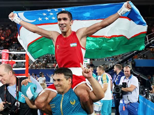 Petinju Uzbekistan, Abdumalik Khalokov, merayakan medali emasnya di Olimpiade 2024. (Foto: AP)