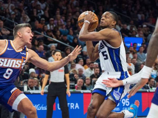 De'Aaron Fox (kanan) mencetak 21 poin saat Sacramento Kings mengalahkan Phoenix Suns 127-118 melalui overtime pada hari Minggu (10/11). (Foto: AP)