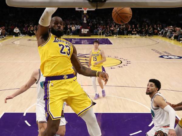 LeBron James (kiri) mencetak triple-double ketiganya secara beruntun saat Los Angeles Lakers menang 128-123 atas Memphis Grizzlies pada hari Rabu (13/11) malam. (Foto: AP)