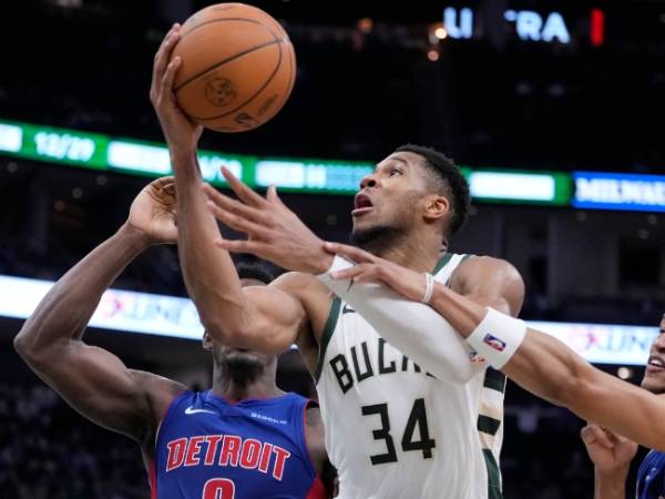 Giannis Antetokounmpo (kanan) membukukan 59 poin saat Milwaukee Bucks mengalahkan Detroit Pistons 127-120 lewat overtime pada Rabu (13/11) malam. (Foto: AP)