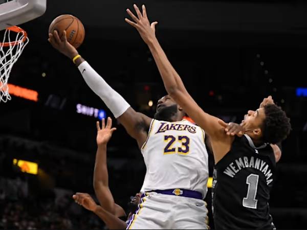 LeBron James (kiri) mencatatkan triple-double keempat beruntun saat Los Angeles Lakers mengalahkan San Antonio Spurs 120-115 pada Jumat (15/11) malam di Piala NBA. (Foto: AP)