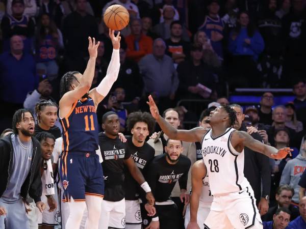 Jalen Brunson (kiri) memasukkan tembakan 3 poin penentu kemenangan saat New York Knicks mengungguli Brooklyn Nets 124-122 pada Jumat (15/11) malam di Piala NBA. (Foto: AP)