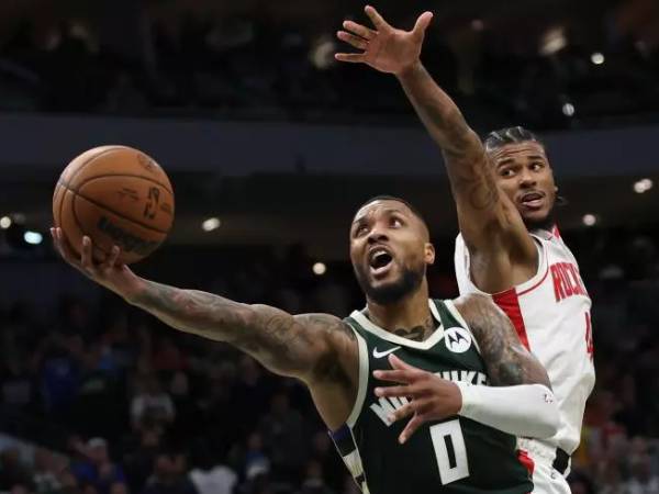 Damian Lillard (kiri) melakukan layup dengan 3,9 detik tersisa saat Milwaukee Bucks meraih kemenangan 101-100 atas tim tamu Houston Rockets pada Senin (18/11) malam. (Foto: AP)