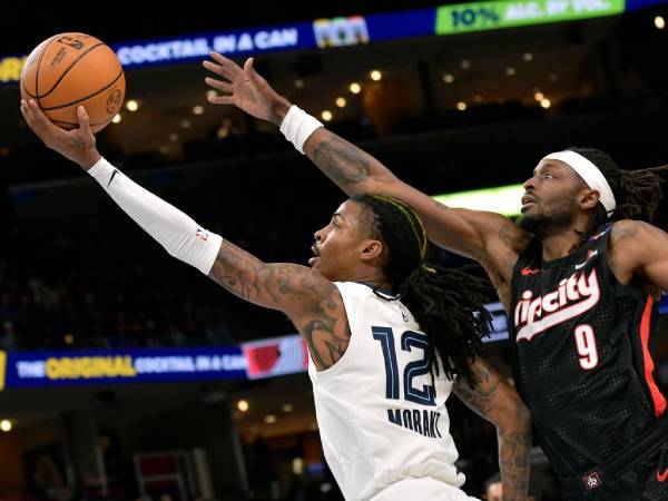 Ja Morant (kiri) mencetak 22 poin saat tuan rumah Memphis Grizzlies menang 123-98 pada Senin (25/11) malam atas Portland Trail Blazers. (Foto: AP)