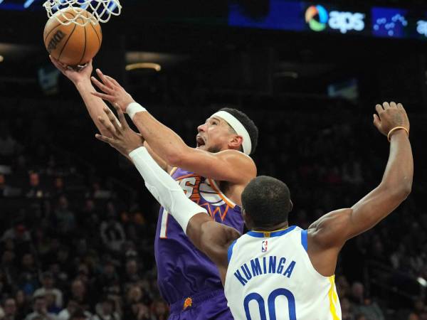 Devin Booker (kiri) mencetak 27 poin saat Phoenix Suns menghentikan tim tamu Golden State Warriors 113-105. (Foto: AP)