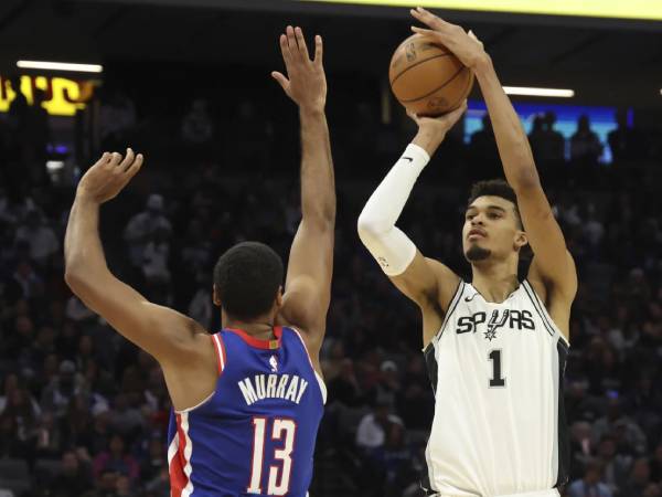 Victor Wembanyama (kanan) membukukan triple-double saat San Antonio Spurs meraih kemenangan 127-125 atas Sacramento Kings pada Minggu (1/12) malam. (Foto: AP)