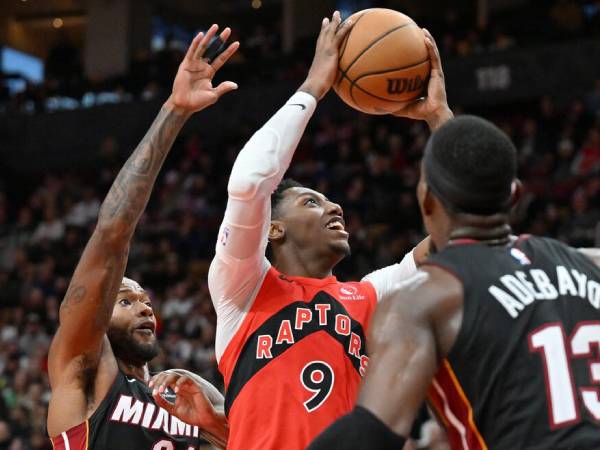 RJ Barrett (tengah) mencetak 37 poin saat Toronto Raptors mengalahkan tim tamu Miami Heat 119-116 pada hari Minggu (1/12) malam. (Foto: AP)