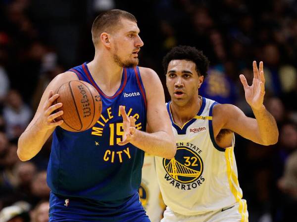 Nikola Jokic (kiri) mencetak 38 poin saat Denver Nuggets mengalahkan Golden State Warriors 119-115 di Piala NBA pada Selasa (3/12) malam. (Foto: AP)