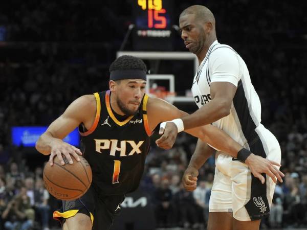 Devin Booker (kiri) mencetak 29 poin saat Phoenix Suns meraih kemenangan 104-93 atas San Antonio Spurs di Piala NBA pada Selasa (3/12) malam. (Foto: AP)