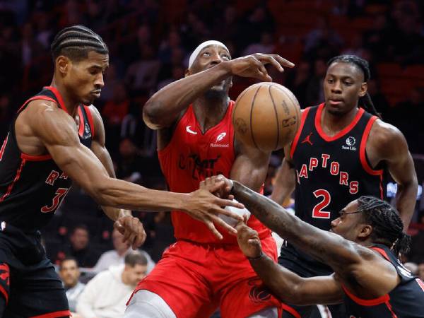 Bam Adebayo (tengah) mencetak 21 poin saat Miami Heat menang 114-104 atas Toronto Raptors pada Kamis (12/12) malam. (Foto: AP)