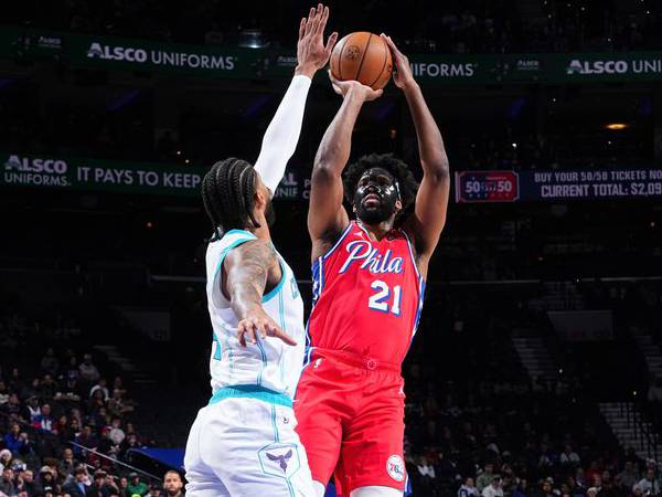 Joel Embiid (kanan) mencetak 34 poin saat Philadelphia 76ers meraih kemenangan 108-98 atas Charlotte Hornets pada Jumat (20/12) malam. (Foto: AP)