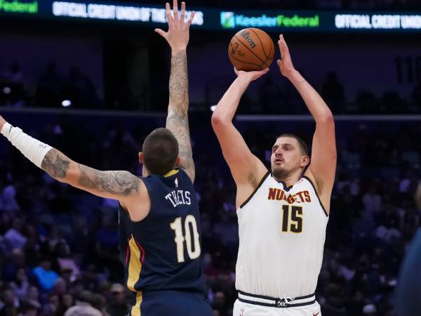 Nikola Jokic (kanan) membukukan triple-double saat Denver Nuggets mengalahkan New Orleans Pelicans 132-129 lewat babak perpanjangan waktu Minggu (22/12) malam. (Foto: AP)