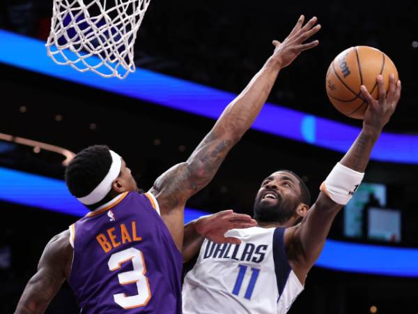 Kyrie Irving (kanan) mencetak 20 poin saat Dallas Mavericks meraih kemenangan 98-89 atas tuan rumah Phoenix Suns pada Jumat (27/12) malam. (Foto: AP)