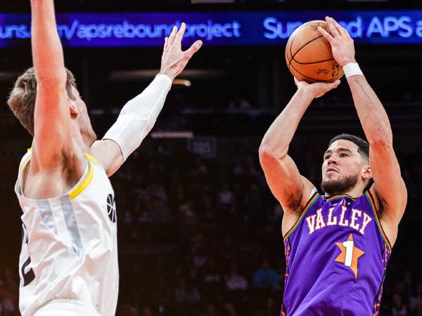 Devin Booker (kanan) mencetak 34 poin saat Phoenix Suns menang 114-106 atas tim tamu Utah Jazz pada hari Sabtu (11/1) malam. (Foto: AP)