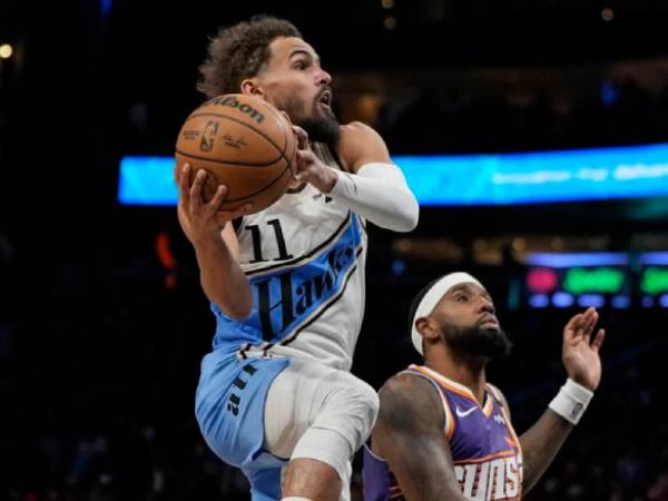 Trae Young (kiri) mencetak 43 poin saat Atlanta Hawks mengalahkan tim tamu Phoenix Suns 122-117 pada Selasa (14/1) malam. (Foto: AP)